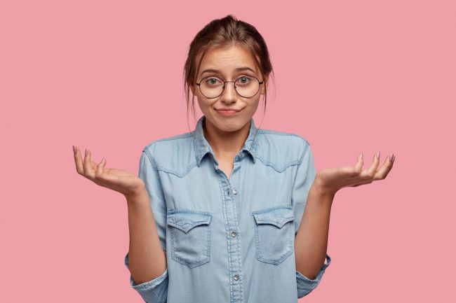 hesitant-uncertain-woman-shrugs-shoulders_273609-28207